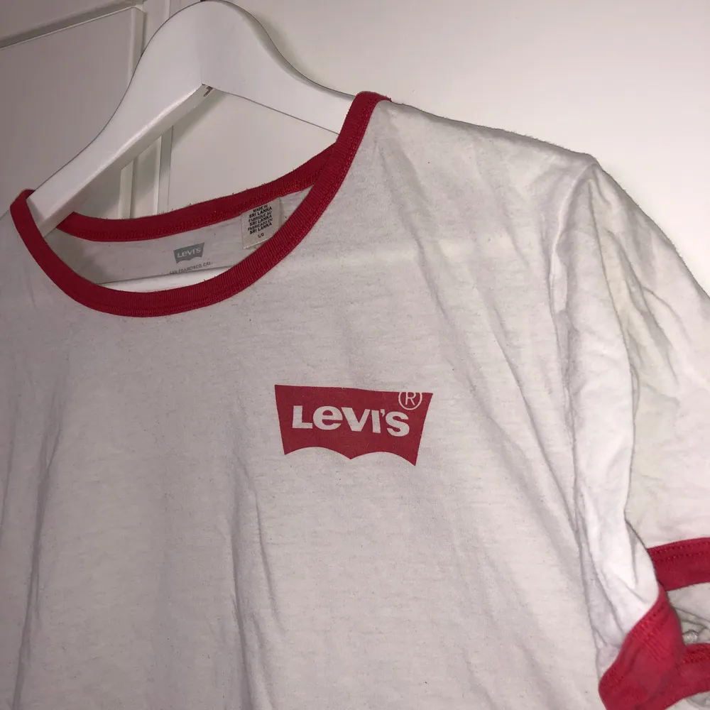Vit Levis T-shirt med röda detaljer. Använt skick. Strl L. T-shirts.