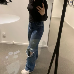 Jeans med hål - Ett par fina mörkblå jeans från zara, dem har ett hål på höger knä och fina detaljer vid foten💕helt felfria och knappt använda! Jag är ca 170 cm