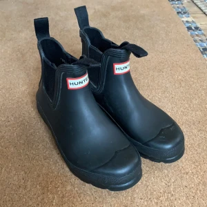 Hunter Chelsea Gummistövlar  - Hunter gummistövlar i Chelsea modell. Perfekta för stadsmiljön då de knappt ser ut som gummistövlar men är helt vattentäta! Köptes för 1100kr, och är i otroligt bra skick. Säljs dock billigare för att det är lite smutsiga här & där. Skriv för fler bilder eller om ni har frågor.