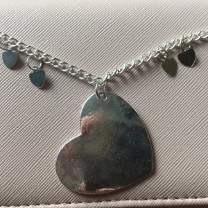 Silvrigt halsband - Silvrigt halsband men ett stort hjärta på och fyra slås hjärtan på. Frakt betalar köparen ( pris kan absolut diskuteras) 