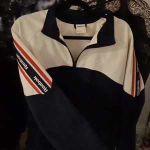 Reebok classic  - En äkta reebok classic i storlek L, fint skick och tvättas såklart innan köp. Väldigt sällsynt då jag ej kan få upp fler av dessa jackor på sökmotorn. Blå, röd & vit i färg och lite "sport" aktigt material. Angett pris är exklusive frakt! 