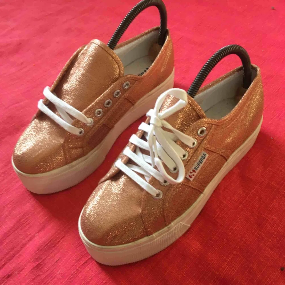 Helt oanvända sneakers med platå från märket Superga. De är bronsfärgat glittriga och riktigt snygga till ett par brunbrända ben i sommar ☀️ 300 plus frakt! . Skor.