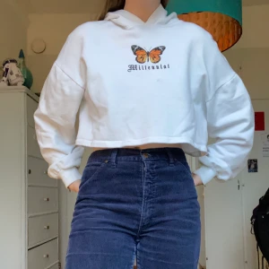 Croppad fjärilshoodie  - En snygg croppad fjärilshoodie med texten ”millennial”. Det finns en liten fläck lite under trycket och lite smutsig på ärmen men annars är den helt ren! Från Bershka😊💕 80kr plus frakt