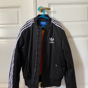 Adidas bomberjacka - Bomberjacka från Adidas, herrmodell i fint skick och i bra kvalite! Använd en gång, köpt på Selvage i Kalmar för 1800 kr, pris kan ev diskuteras.