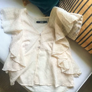 Söt blus storlek M - Söt beige blus med prickar. Aningen transparent men den går definitivt att bära med bara bh under. Storlek M men passar absolut S. Kan vara bra att veta att under dem tre knapparna är det öppet. Kan dela på frakten vid snabb affär