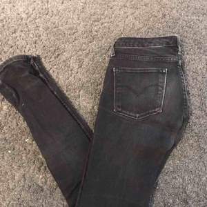 Svarta levis jeans som uppskattas till storlek S eller 25. De är super snygga och lätta att styla. 
