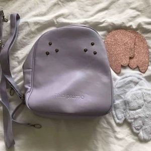  - Lila väska köpt i Tokyo. Aldrig använd!   Med väskan får du med två par olika vingar och remmar så du kan bära den som en ryggsäck.
