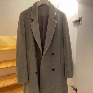  - Vinterkappa i grå kashmir uppsydd hos skräddare. 