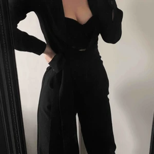  - Svart byxdress i storlek XS med djup V-ringning och knytskärp. Passar mig som är 160 lång