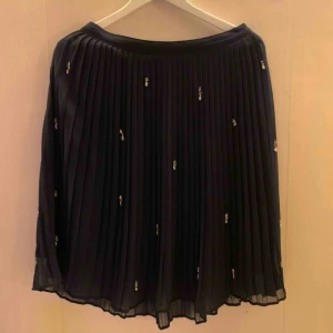  - Marinblå knälång plisserad kjol från Zara. Ett fåtal stenar sitter löst, men inget som inte lite sytråd och nål kan lösa!   Jag kan mötas upp i Borås, eventuellt Göteborg. Annars står köparen för frakten. 