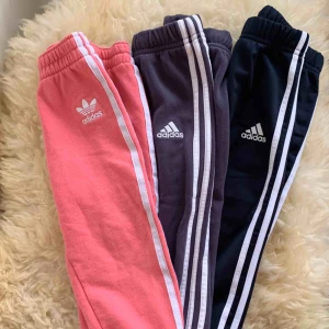  - Tre stycken adidas byxor säljes i paket. Strl 86 12-18 mån. De rosa är lite mer slitna än de andra. De mörkblåa/marin är i fint skick, som nya. Djur- och rökfritt hem.
