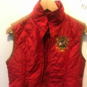  - Röd väst från Ralph Lauren, storlek M. Polyester/kalvskinn. Fint skick! 