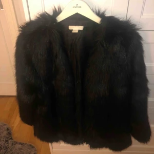  - Köparen står för frakt (50kr) annars finns jag i Eskilstuna. Långhårig svart pälsjacka från H&M, köpt för två år sedan, sällan använd och i bra skick. Lite större i storleken. Stängs med hakar och har två ytterfickor.