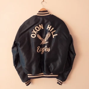  - Bomberjacka - fluffig och varm!! OXON HILL Eagles. Lite skinande och jätteskön. Vinterjacka Den har några små ljusbruna fläckar som jag inte tror går att få bort. Bild 3 på en av de.