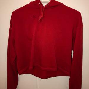 En röd croppad tröja från H&M, har använts 1 gång. Har även en luva där bak. Storlek XS men passar även S. Ordinarie pris: 100 kr