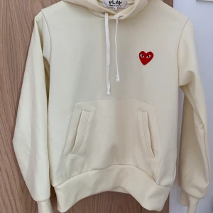 Cdg PLAY Hoodie  - En gul fin cdgPlay hoodie. Bra skick och knappt använd. Jag är en xs/s men köpte i strl L för att den inte skulle sitta tight. Funkar i alla strl skulle jag säga beroende på hur man vill att den ska sitta. (Förhandling om pris ok) 