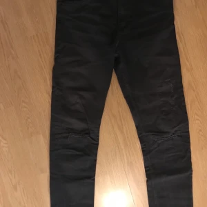 H&M Skinny fit Stretch jeans med hål - Jeans från H&M i SkinnyFit Stretch. De har fabriksgjorda hål vid knäna men bekvämt nog så sitter det en innerlapp som gör att hålet inte går igenom hela byxan. Storlek 170 Byxorna är i gott skick. Säljer de eftersom jag har växt ur de.