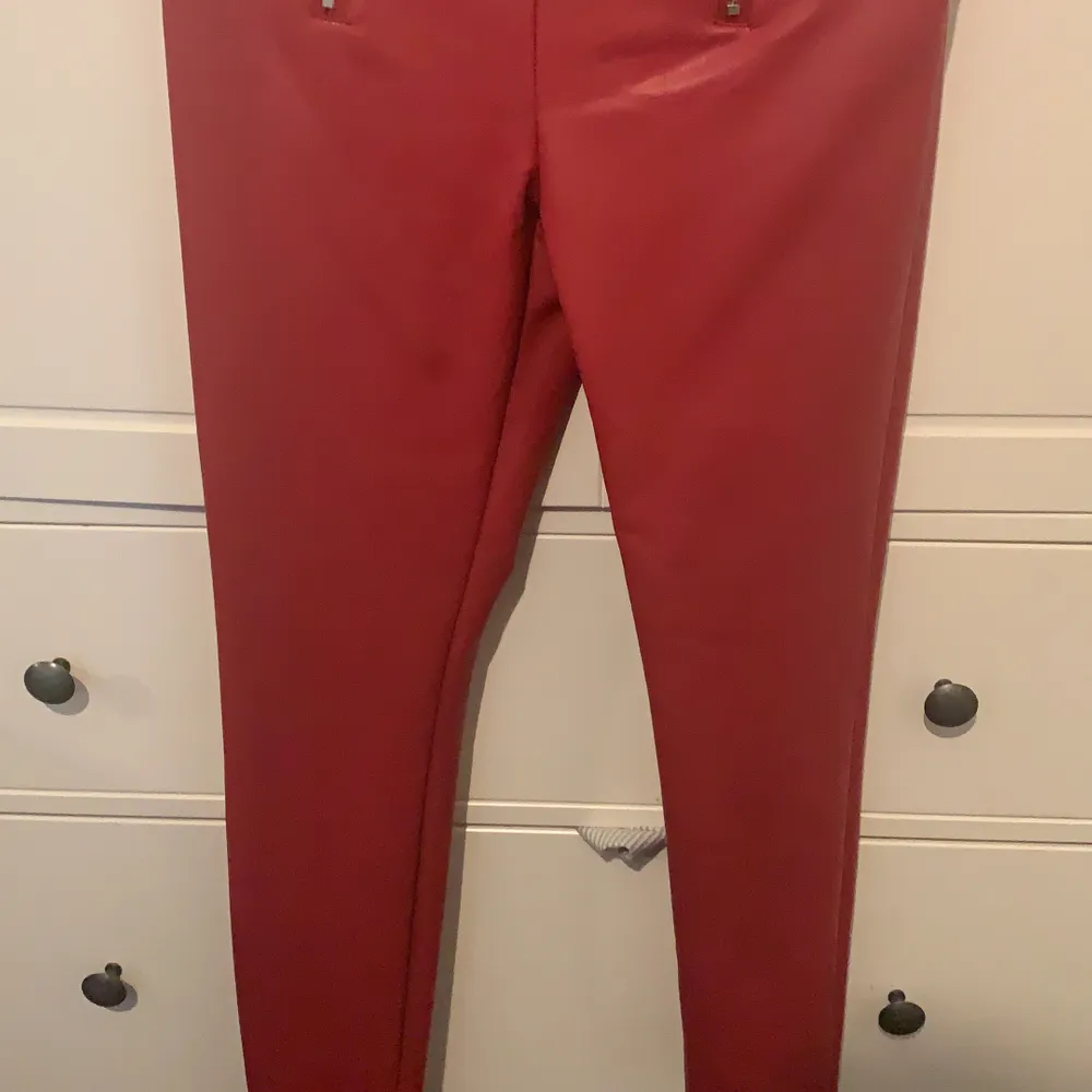 Röda skinnbyxor med väldigt fin detalj aldrig använd i strl M sätter sig jätte fint på kroppen. Jeans & Byxor.
