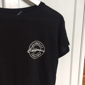  - Svart t-shirt med tryck. Plus frakt. Betalning via swish. 