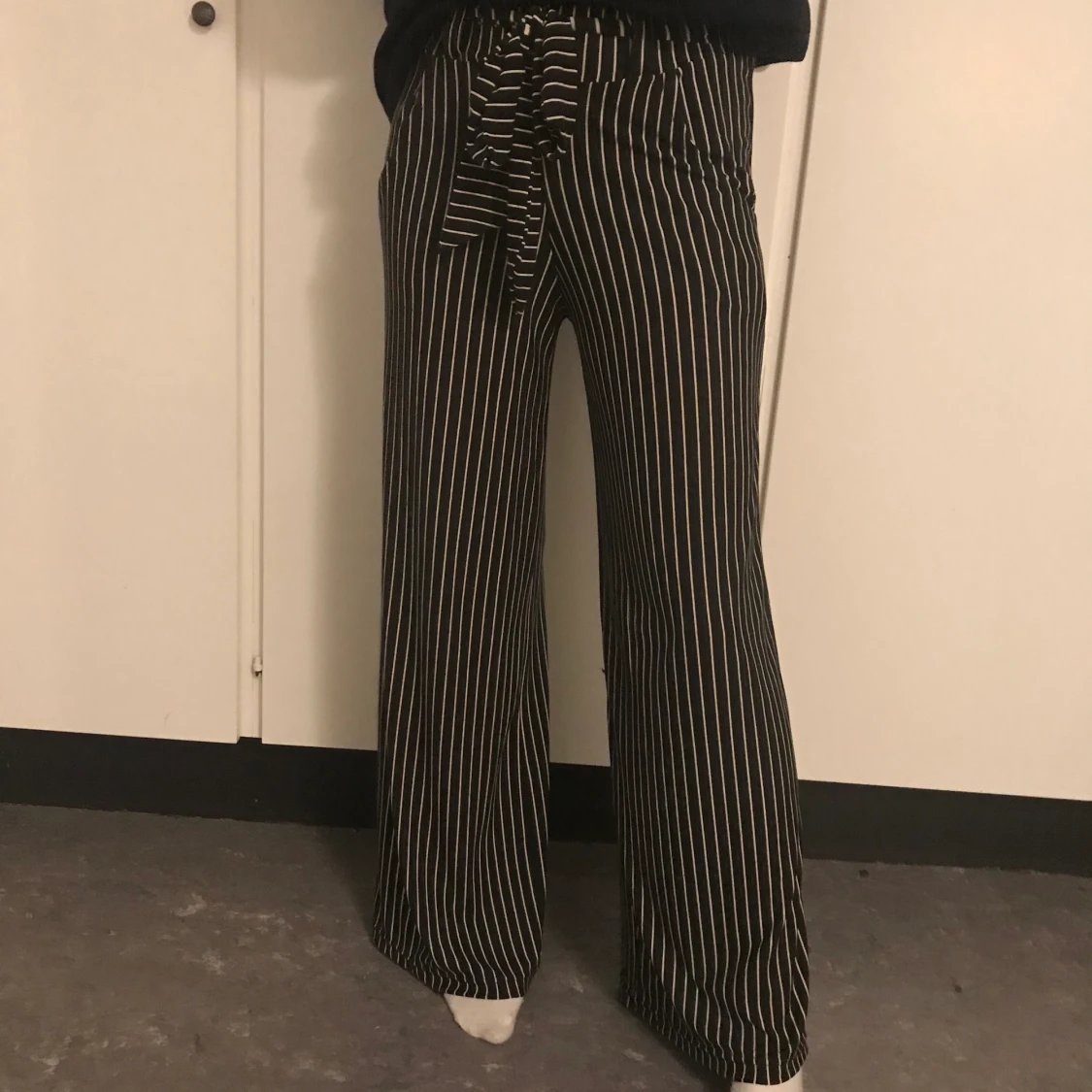 Svarta byxor med vita ränder