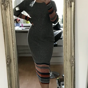 Stickad maxiklänning från H&M - Grå, stickad maxiklänning från H&M! Orangea/blåa ränder nere på klänningen och nere på armarna. Storlek xs men är stor i storleken.