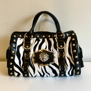 Zebramönstrad väska  -  Har bestämt mig för att sälja världens coolaste väska! zebramönstrad med asfeta detaljer så som nitar och ett lejonhuvud?! Väskan är i jättebra skick och lagom stor!  Köper du detta statement piece kommer du va ballast i stan och alla kommer vilja ha dig, eller den?😉  bjudgivning sker i kommentarerna (obs bud med Minst 10 kr) för vidare frågor skriv i dm:s 🥰💕
