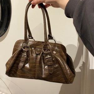 Brun vintage väska - Brun väska från Jane Norman, vad jag vet så säljs den ej längre. Jättefint skick! Öppningen den har gör väskan rymlig. Den har ett litet innerfack. Bud från 50:- + frakt. Sluttid sätts nästa vecka☺️🌸