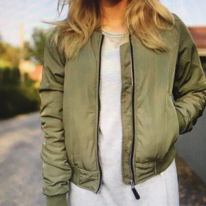 Grön bomberjacka - Grön bomberjacka i storlek L säljes! Jackan är i fint skick och finns att hämta i Bandhagen! Kan också skickas mot att köparen står för frakten.