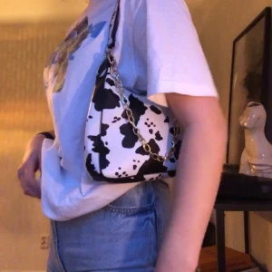 Komönstrad väska - Säljer min fina väska med komönster, den är helt oanvänd då det inte riktigt är min stil så i perfekt skick! Guldkedjan går att ta av o på och axelbandet är reglerbart 🦋