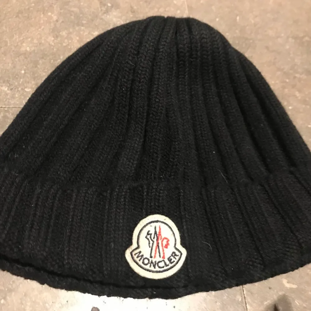 Säljer en svart (beanie?) moncler mössa. Den är äkta och köpt för ca 2000kr. Innerlappen har tappat färg på texten, men märket och materialet visar äkteheten❤️ Den är bra skick inga fläckar eller så! Oklart vad det är för storlek men passar nog dem flesta😊. Övrigt.