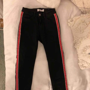  - Svarta jeans med röd rand på sidan av benen, köpta från Chelsea i storlek 36. Nästan helt oanvända!  Köparen står för frakt!