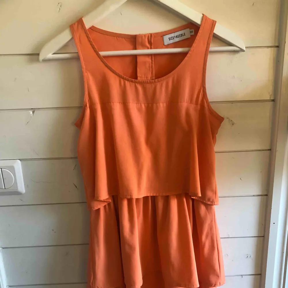 Orange klänning med volanger, köpt på torp för tre/fyra år sedan. Använd 1 gång! Köparen står för frakten. Klänningar.