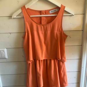 Orange klänning med volanger, köpt på torp för tre/fyra år sedan. Använd 1 gång! Köparen står för frakten