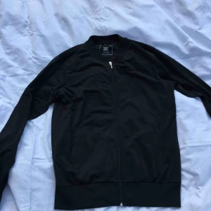  - Svart tröja med tryck på baksidan