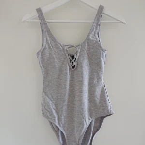  - Grå body från H&M i storlek S. Aldrig använd och i mycket bra skick! 