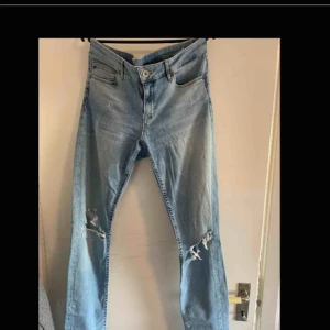 - Blåa jeans med hål i båda knäna. Endast använda ett par gånger.