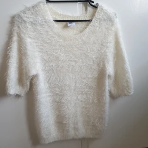 - Stickat vit tröja med korta ärmar. Oanvänd och väldigt vacker! 