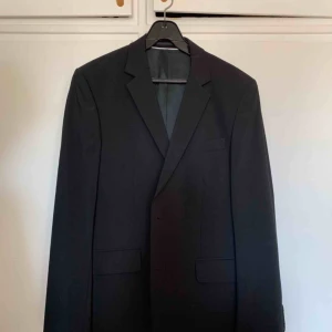  - Svart herrkostym från Riley. Köpt på Brothers för ett par år sedan för ca 3000:-, men bara använd två gånger så den är i nyskick.  Kavaj storlek 48 Kostymbyxor storlek 50  Kan hämtas i Malmö eller skickas om köparen står för frakten:) 