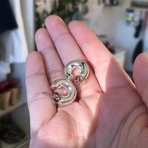Silvriga örhängen - Små tjocka hoops. Snygga att ha till andra örhängen. Fint skick och inga missfärgningar. Frakt: 10kr