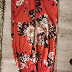 Nakd röda byxor med blommor - Supersnygga byxor som tyvärr blivit försmå för mig. De har jättesnygg passform med raka ben. Resår i midjan. Storlek small. 