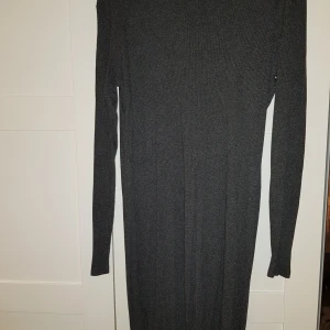 Väldigt fin klänning, bra material - En figurnära klänning i mörkgrått. Sitter riktigt fint samt mjukt och skönt material. Använd 1 gång.