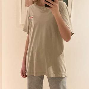 Beige oversized t-shirt från Weekday. Trycket ”solar energy” på framsidan och ”24/7 hours” på baksidan. Använd ett par gånger men fortfarande i bra skick!