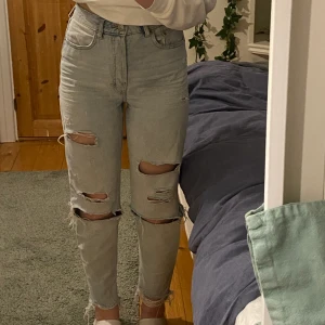 Superfina mom jeans i bra skick! - Jättefina mom jeans från H&M. Väl använda men fortfarande i fint skick💗 Har många hål och slitningar varav några av hålen har blivit ännu större än urpsrungligen men det är inte något som märks! Jag är ca 165 och de passar mig bra på längden :)