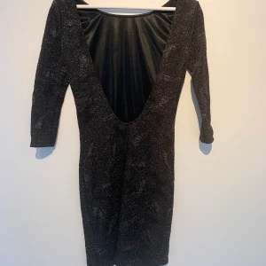 Ny klänning/ Zara/ Storlek S - Festklänning i svartglittrigt mönstrat tyg, som tyvärr bara fått hänga i garderoben. Klänningen har en djup urringning i ryggen och är figursydd. Storlek small. Den är lagom lång och slutar en liten bit ovan knäna.   Se gärna mina övriga försäljningar för samfrakt :)