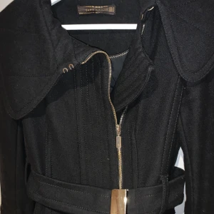 Svart kappa - Svart trenchcoat i ull figursydd med bälte i midjan 