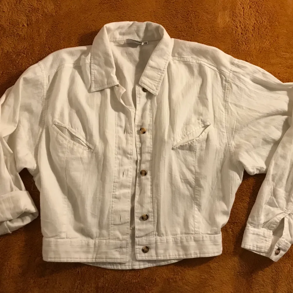 En vit skjorta som funkar ungefär som en jacka/kofta. Lite tjockare tyg och sitter sjukt snyggt🍃 det är min mammas gamla så tror den är rätt gammal, dock i bra cond! Lite croppad, så fin med en klänning eller linne och jeans! Byxorna säljs på profilen också. Skjortor.