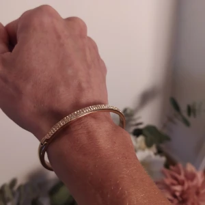 Armring, rosé guldpläterad med stenar på ena sidan.  - Nyskick, helt repfritt 