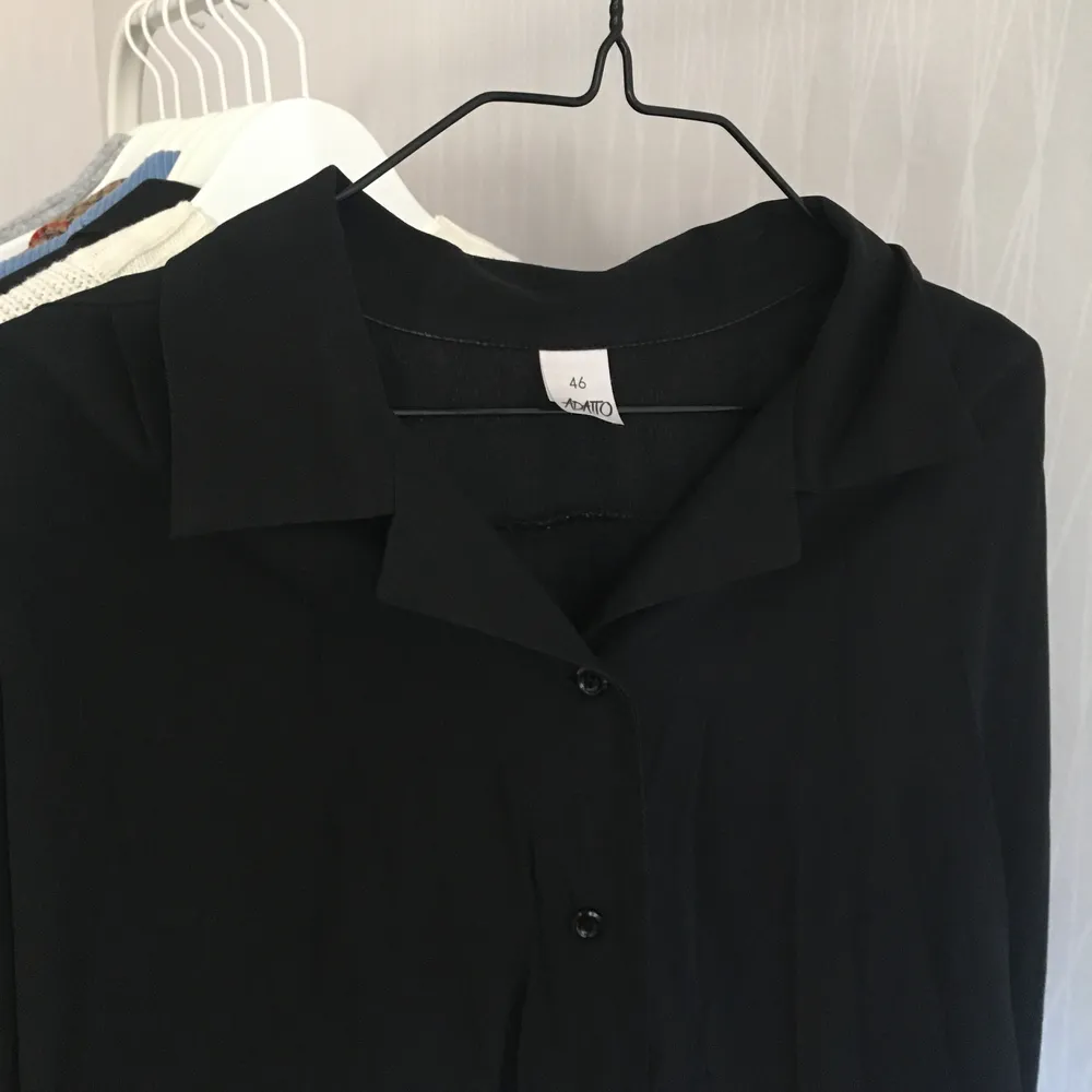 En stor svart skjorta i mjukt och följsamt material.  Jättenice att bara slänga på över ett linne. Storlek 46, visas på bild på en 38/M. Väl använt skick, köpt second hand. Frakt tillkommer. Skjortor.