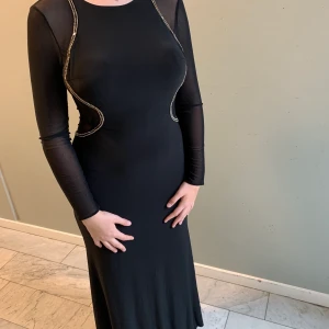 Festklänning - Festklänning i meshdetaljer. Klippt i längden så lite ojämn