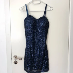  - Marinblå figursydd paljettklänning från Nelly. Med avtagbara axelband. Supersnygg modell och i stretchigt material. Använd en gång.